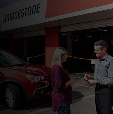 Customer receiving a logbook car service on her vehicle from a qualified mechanic.