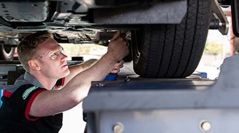 Car repair being completed by a qualified car mechanic servicing a vehicle to ensure car safety. 