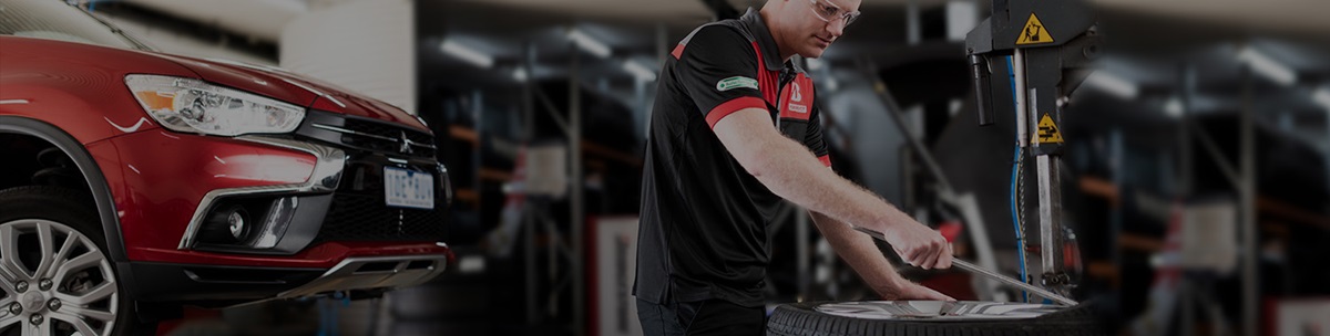Tyre mechanic servicing a tyre punctured repair on a punctured tyre.