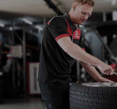 Tyre mechanic servicing a tyre punctured repair on a punctured tyre.