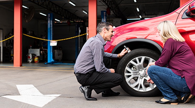 Expert tyres mechanic advising about the car tyres to the customer